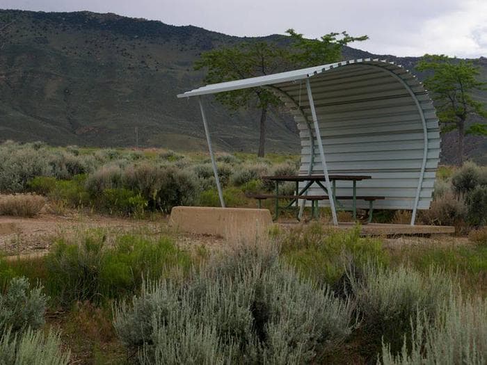 Picnic table with a shelter covering one side and over head.