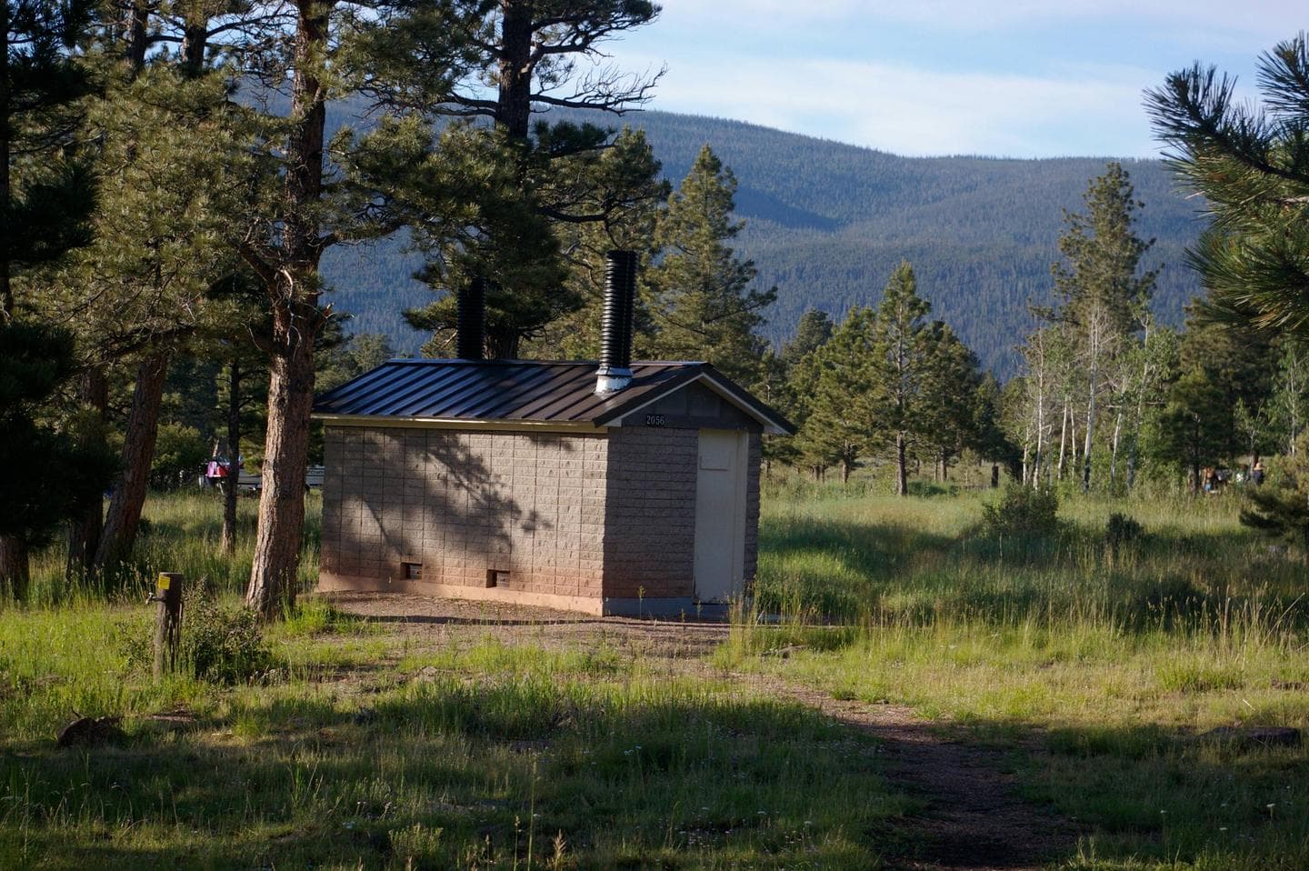 Brick building with a siding roof that houses the restrooms.