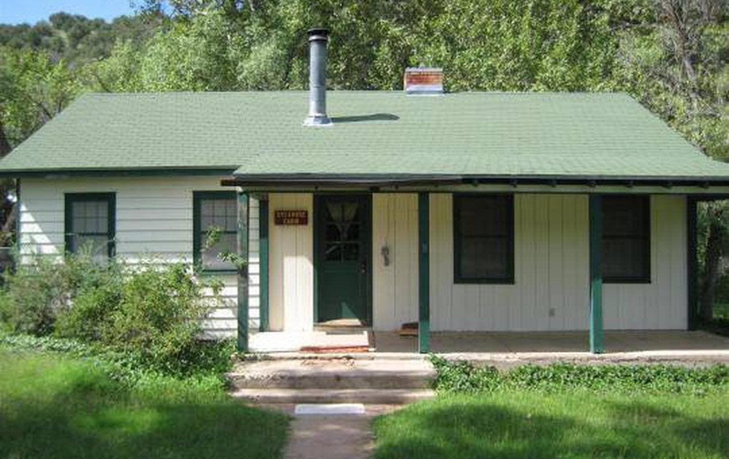Sycamore cabin with three stairs to front door. Wide covered porch.