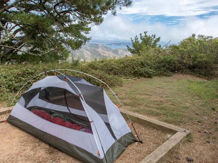 A tent in a tent pad at Hawk Campground, with a glimpse of the view in the background.