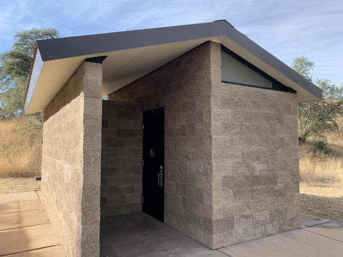 A stone pit toilet building.
