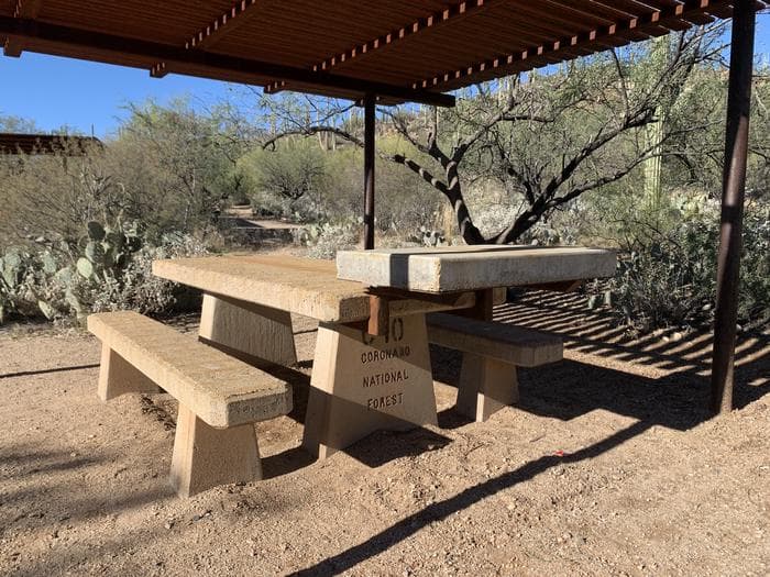 a stone picnic table in surrounding area outside the ramada
