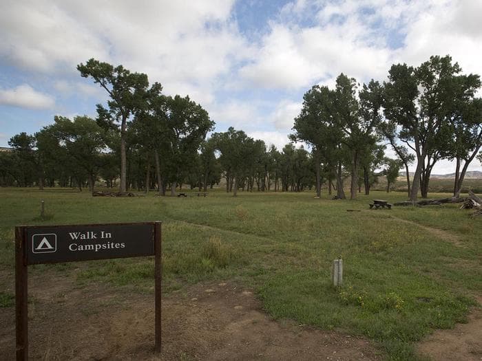Sign in front of the Deerlodge Campground Walk-in Sites with trees in the background