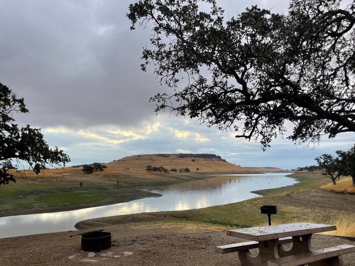Campsite within Buckhorn Campground showing picnic table, firepit, and the view of the lake.